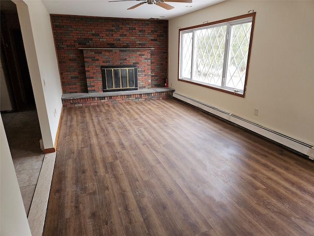 unfurnished living room with baseboard heating, a ceiling fan, a brick fireplace, wood finished floors, and baseboards