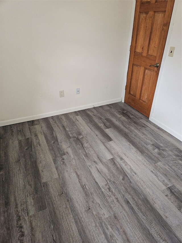 unfurnished room featuring baseboards and wood finished floors