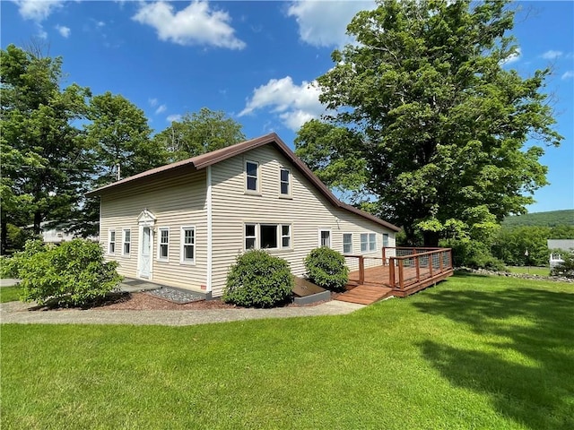 view of side of property featuring a lawn and a deck