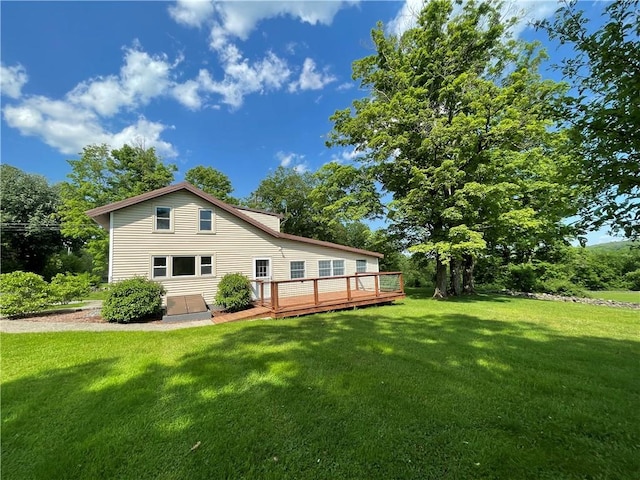 rear view of property featuring a deck and a yard