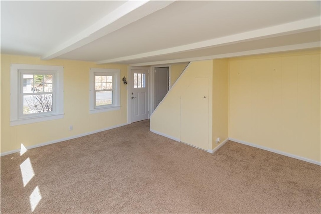 spare room featuring beam ceiling and carpet floors