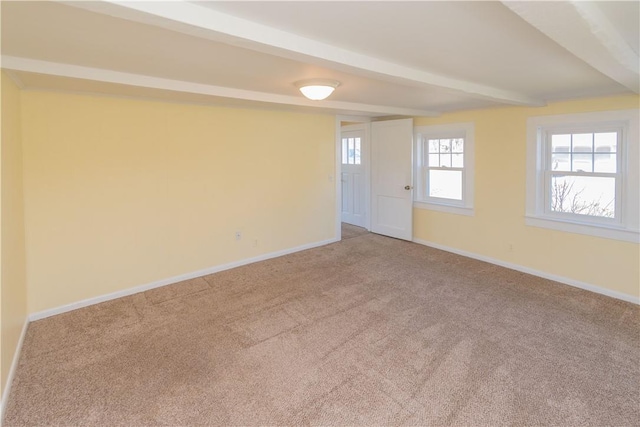 unfurnished room with beamed ceiling and carpet floors