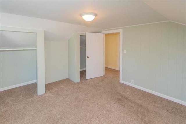 unfurnished bedroom with lofted ceiling and light carpet