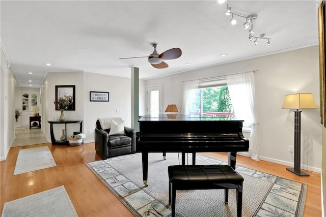 misc room with ceiling fan, light wood-type flooring, and ornamental molding