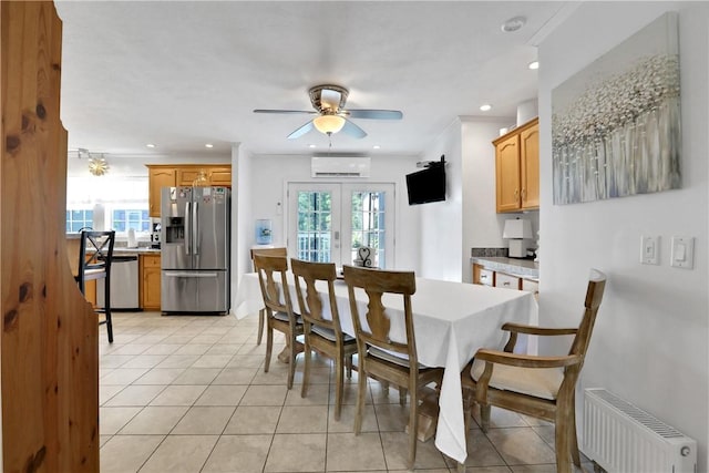 tiled dining room featuring an AC wall unit, a wealth of natural light, radiator heating unit, and french doors