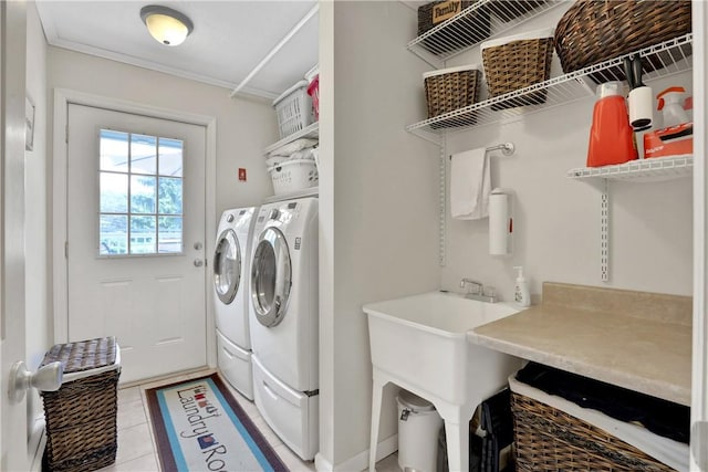 laundry room with sink, light tile patterned floors, ornamental molding, and washing machine and clothes dryer