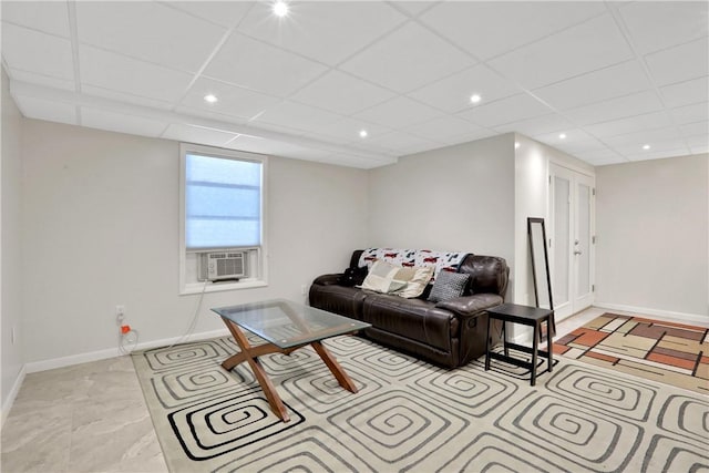 living room featuring a paneled ceiling and cooling unit