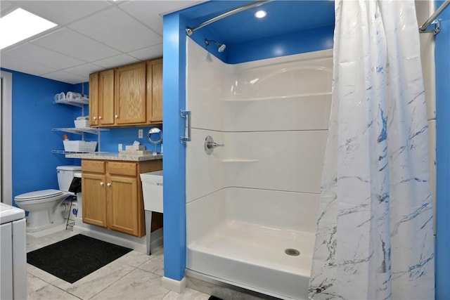 bathroom with vanity, a drop ceiling, toilet, and walk in shower