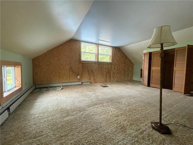 additional living space with wood walls, lofted ceiling, and carpet floors