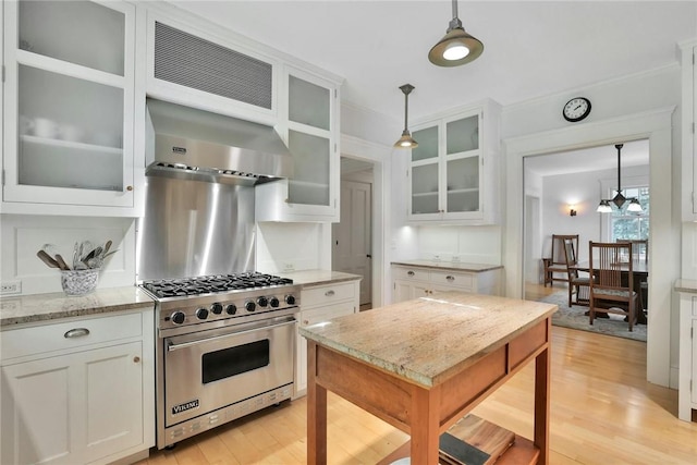 kitchen with white cabinetry, luxury range, and pendant lighting