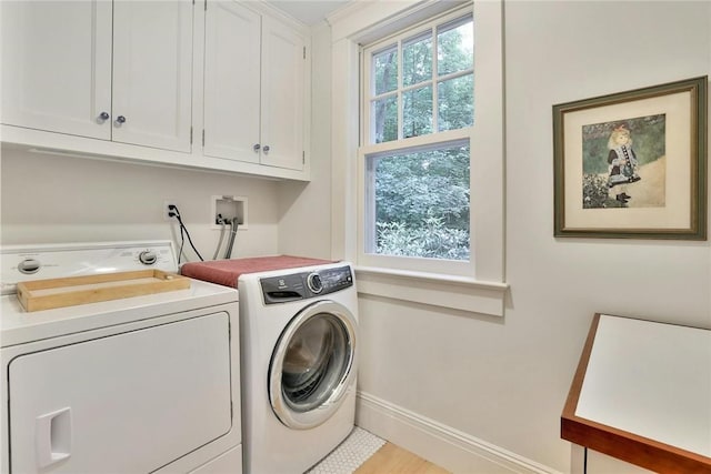 washroom featuring washer and dryer and cabinets