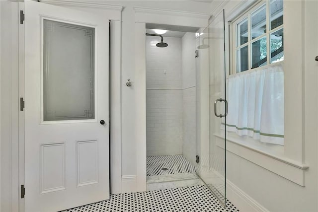 bathroom with tile patterned flooring, walk in shower, and crown molding