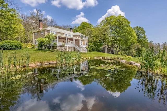 rear view of property featuring a yard and a water view