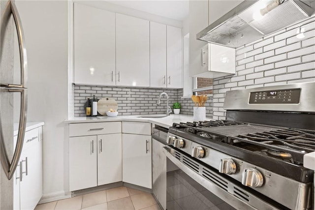 kitchen featuring appliances with stainless steel finishes, ventilation hood, sink, light tile patterned floors, and white cabinets