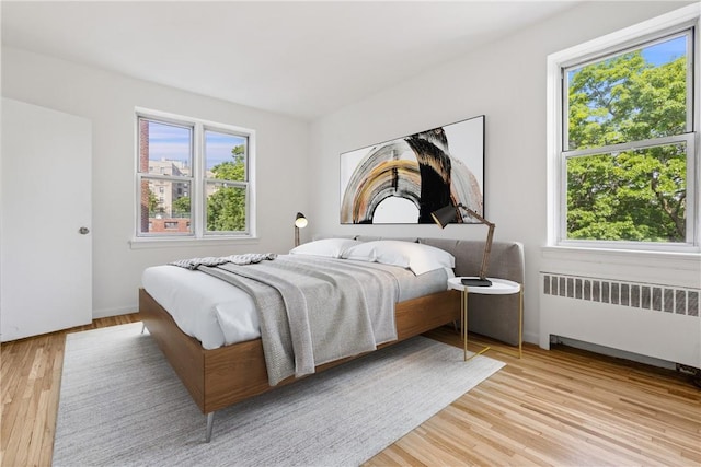 bedroom featuring light hardwood / wood-style flooring and radiator