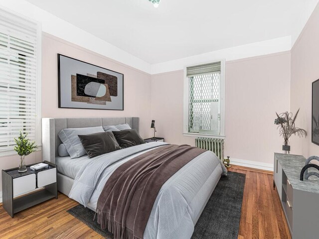 bedroom featuring radiator and hardwood / wood-style floors