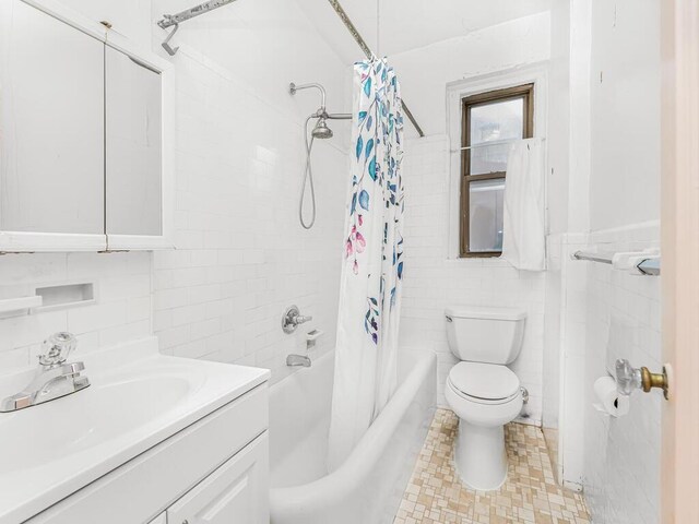 full bathroom with shower / bath combination with curtain, vanity, toilet, and tile walls