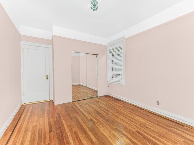 unfurnished bedroom with light hardwood / wood-style floors and a closet