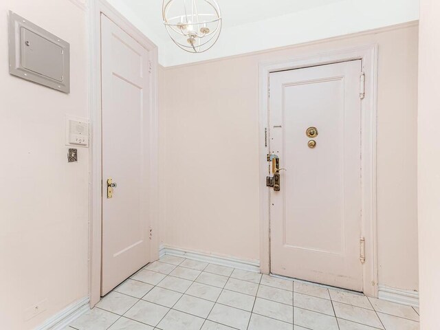 doorway with a notable chandelier and light tile patterned floors