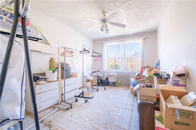 bedroom featuring radiator, ceiling fan, and a textured ceiling