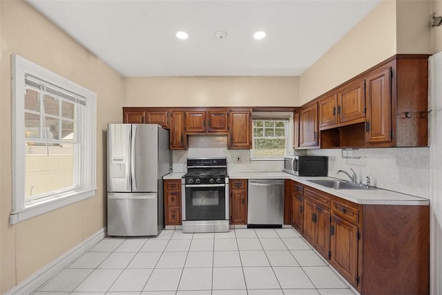 kitchen featuring decorative backsplash, sink, light tile patterned flooring, and appliances with stainless steel finishes