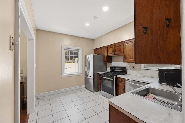 kitchen featuring sink, light tile patterned floors, and appliances with stainless steel finishes