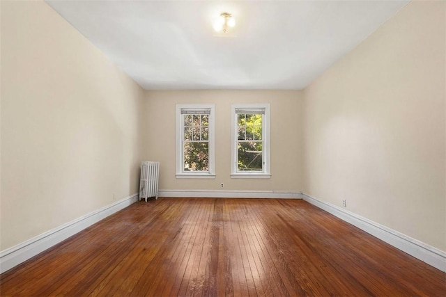 unfurnished room featuring wood-type flooring and radiator