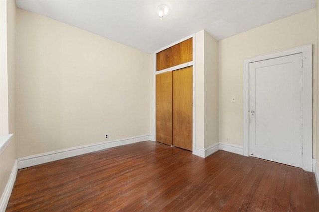 unfurnished bedroom with dark hardwood / wood-style floors and a closet