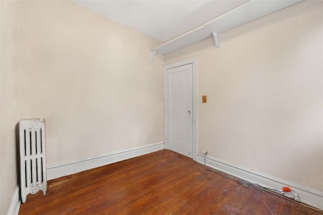 unfurnished room featuring wood-type flooring and radiator