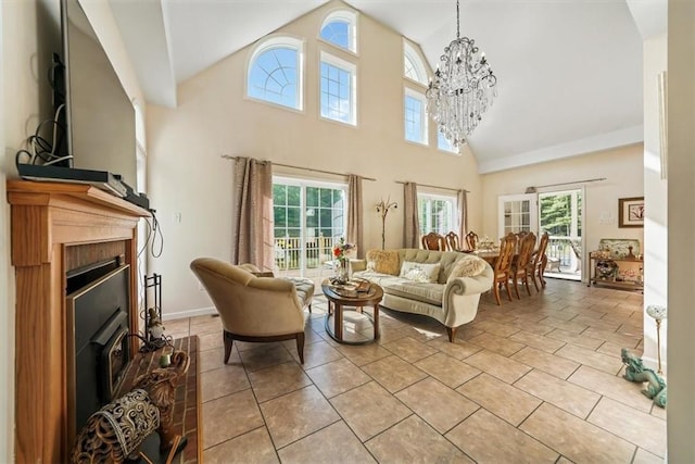 living room featuring a wealth of natural light, high vaulted ceiling, and a notable chandelier