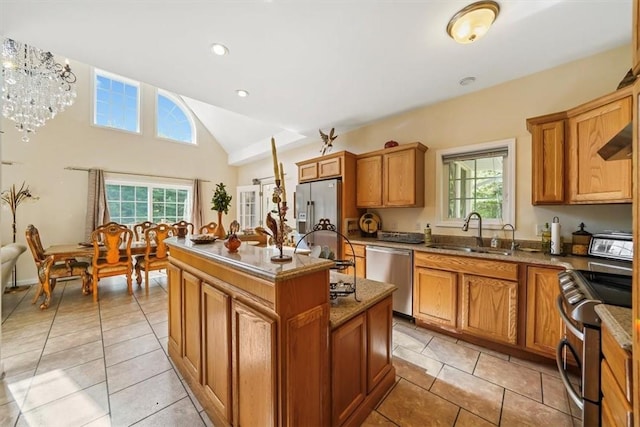 kitchen with appliances with stainless steel finishes, a kitchen island, a wealth of natural light, and sink