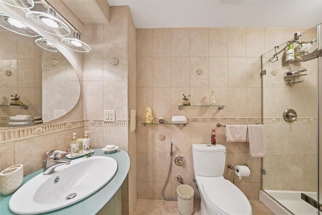 bathroom featuring a tile shower, vanity, tile walls, and toilet