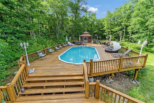 view of swimming pool with a gazebo and a deck