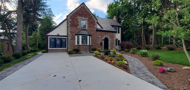 english style home with a front lawn