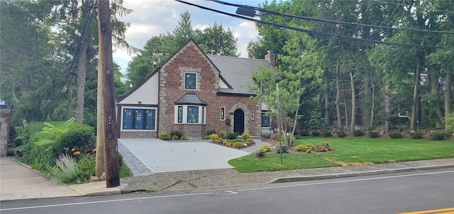 english style home with a front yard