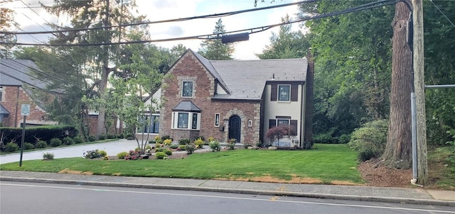 english style home with a front lawn