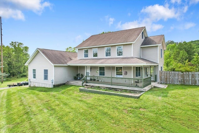 rear view of property featuring covered porch and a yard