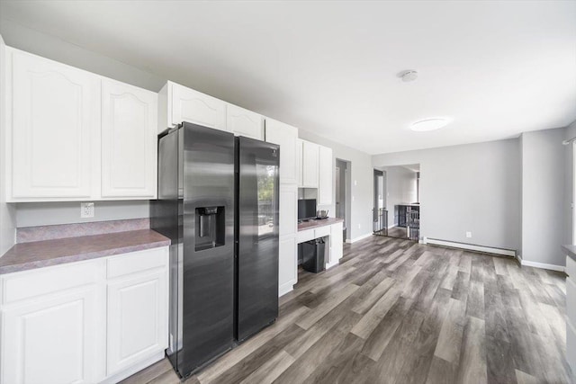 kitchen with white cabinets, dark hardwood / wood-style flooring, baseboard heating, and black refrigerator with ice dispenser