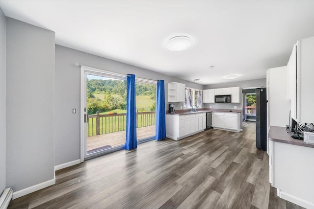 kitchen with white cabinetry, sink, dark wood-type flooring, a baseboard radiator, and black appliances