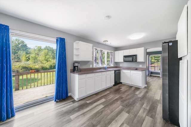 kitchen with white cabinets, wood-type flooring, sink, and black appliances