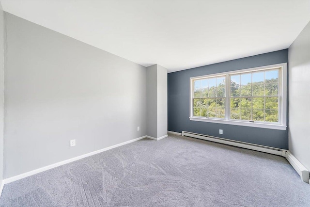 carpeted spare room featuring a baseboard heating unit