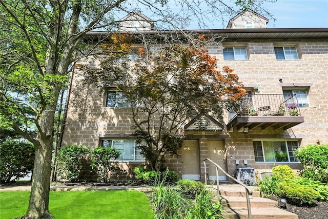 multi unit property featuring a front yard and a balcony