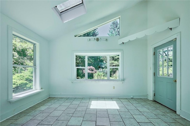 interior space featuring lofted ceiling with skylight and light tile patterned floors