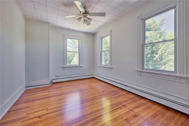 empty room with ceiling fan, a baseboard radiator, and light hardwood / wood-style flooring