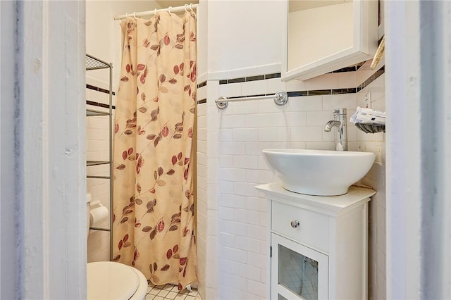 bathroom with vanity, toilet, curtained shower, and tile walls