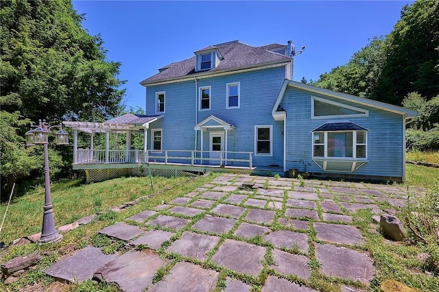 back of house with a wooden deck, a pergola, and a patio