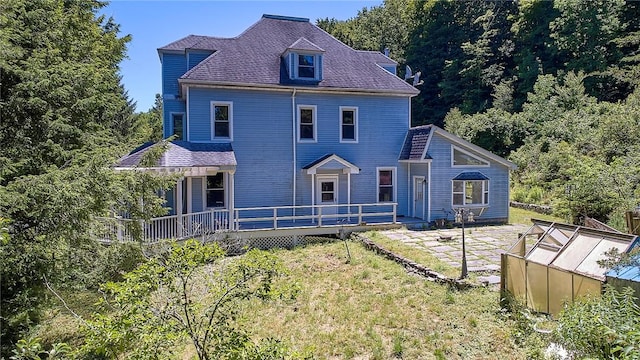 rear view of property featuring an outdoor structure