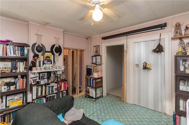 sitting room with ceiling fan and crown molding