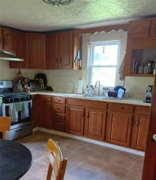 kitchen with a textured ceiling, sink, extractor fan, and stainless steel electric range