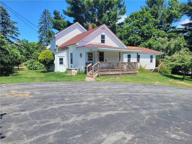 view of front facade featuring covered porch and a front lawn